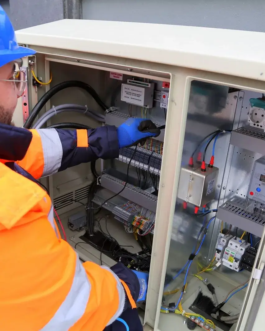 Technician in safety gear working on a wall-mounted unit