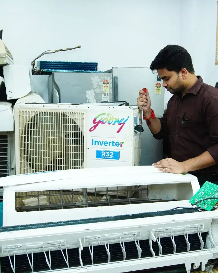 Technician servicing an open air-conditioning indoor unit