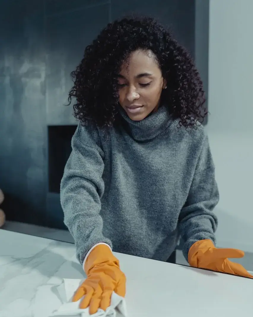 Cleaner wiping a table in a living room