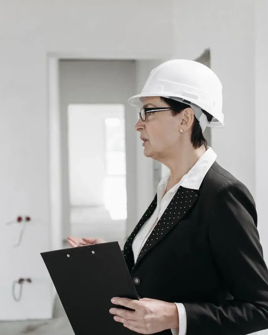 Engineer in a helmet reviewing a clipboard on site