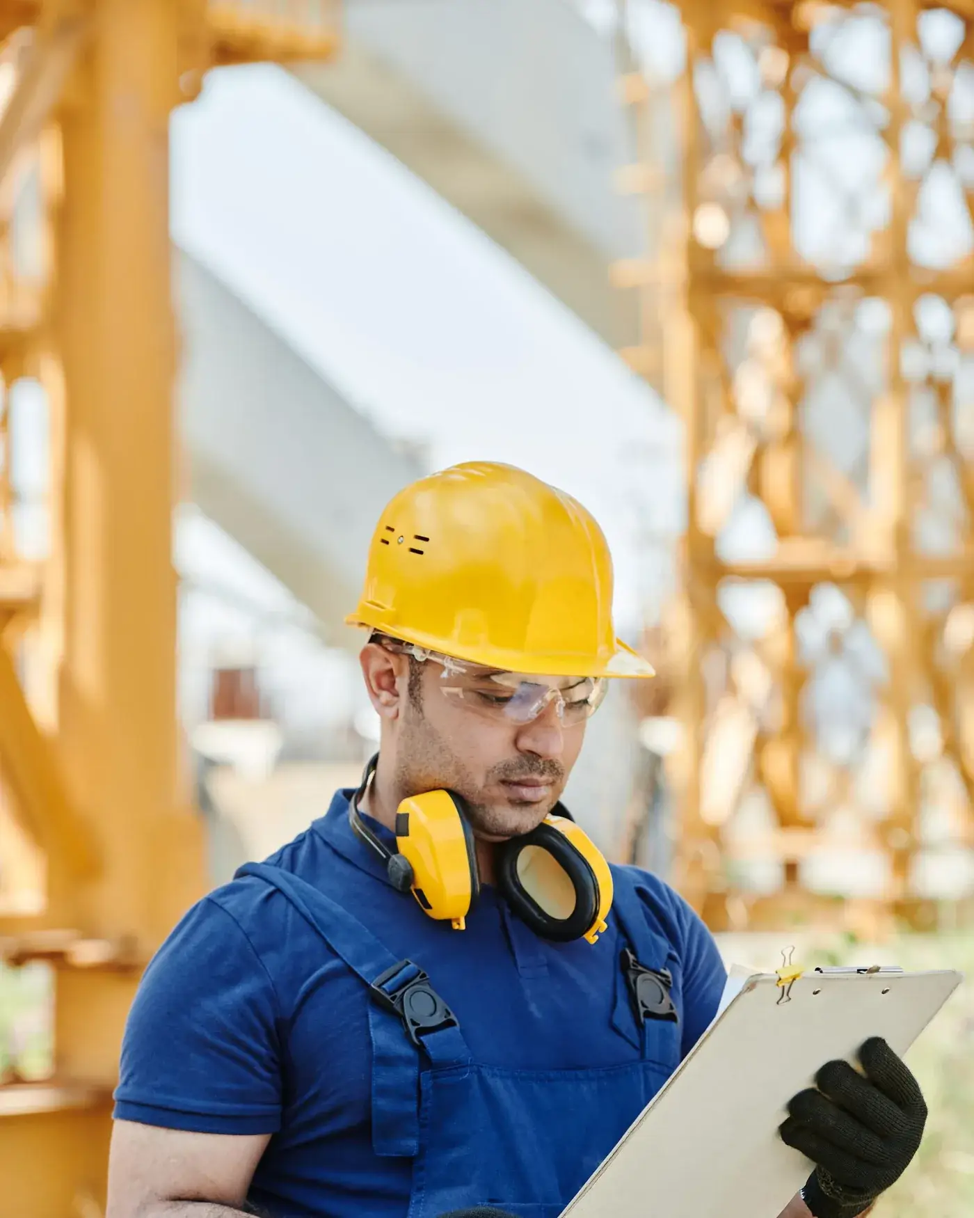 Technician in a hard hat with a clipboard